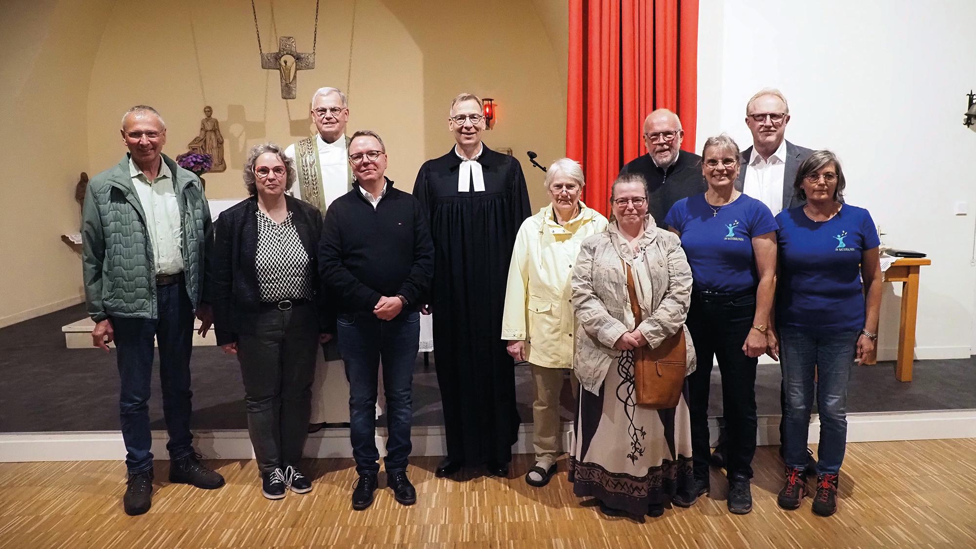 Das Team und weitere Weggefährten der KiNa: Bernd Schmitt (Muhl), Gemeindereferentin Gerlinde Paulus-Linn (Pastoraler Raum Hermeskeil), Bischofsvikar Dr. Ulrich von Plettenberg (Bistum Trier), Pastoralreferent Claus Wettmann (Pastoraler Raum Idar-Oberstein), Superintendent Dr. Jörg Weber (Evangelischer Kirchenkreis Trier), Pfarrerin i.R. Elke Füllmann-Ostertag (Börfink), Dorothee Slabschi (Trier), Pfarrer Arndt Fastenrath (Evangelischer Kirchenkreis Obere Nahe), Gabi Kretz (Muhl), Peter Kretz (Muhl) und Anne Speicher (Nationalparkamt)